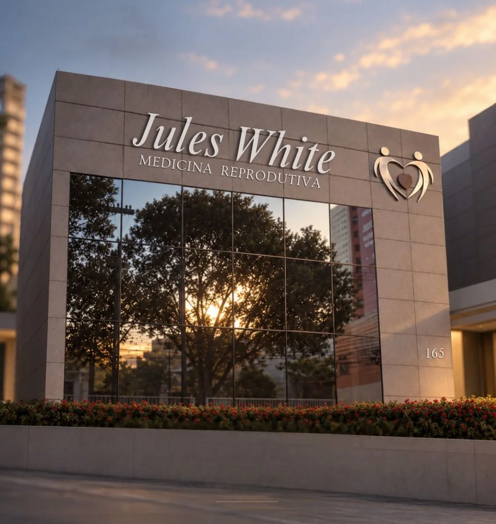 Fachada da clínica Jules White Medicina Reprodutiva, número 165, com vidraças refletindo uma árvore ao pôr do sol.